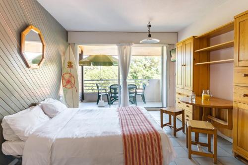 奥瑟戈尔Résidence du Parc Hossegor的一间卧室配有一张床和一张桌子及椅子