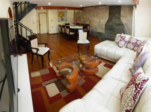 普孔Casa céntrica por día en Pucón的客厅配有白色的沙发和桌子