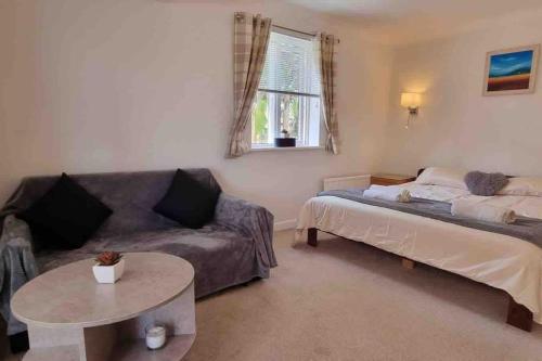 佩恩顿3 Bedroom Bungalow with great Sea Views, Private Hot Tub & Gardens的带沙发、床和桌子的客厅