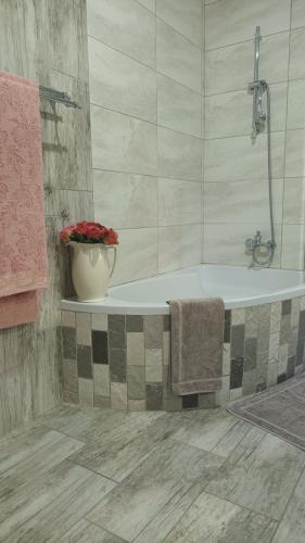 威特班克Lushof Guesthouse的带浴缸和花瓶的浴室