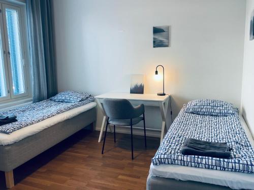 埃斯波STAY Matinkylä Apartments的一间卧室配有书桌、一张床和一把椅子
