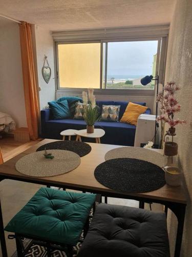 纳博讷普拉日Appartement T2 27m² meublé, vue mer à 50m de la plage的客厅配有蓝色的沙发和桌子