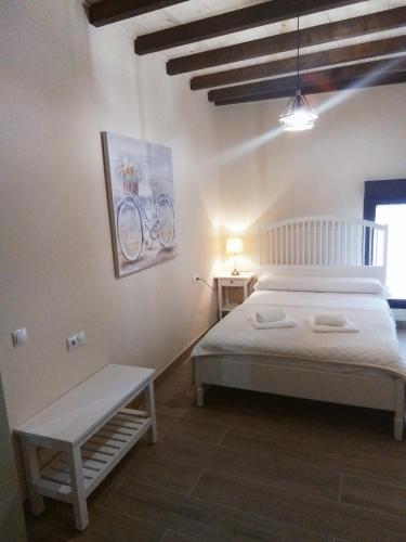 帕德隆Hostel & Rooms Casa Maia的卧室配有白色的床和长凳