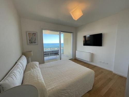 基亚瓦里Gli Scogli Luxury Residence Hotel的一间卧室配有一张床、一张沙发和一台电视