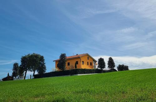 San FilippoCasale Ermo Colle的绿色山顶上的黄色房子