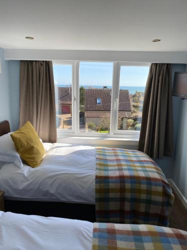 克雷尔Honeypot Guest House的一间卧室设有一张床和一个大窗户