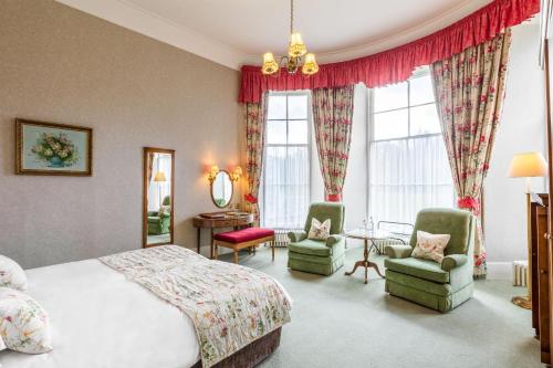 盖特豪斯厄夫弗利特Cally Palace Hotel & Golf Course的一间卧室配有一张床、两把椅子和一张桌子