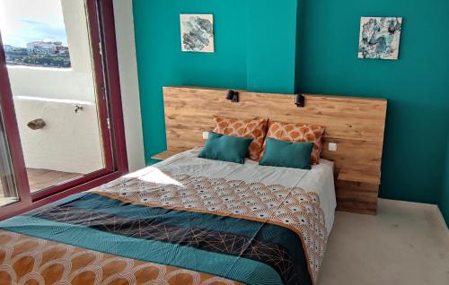 卡萨雷斯Appart cosy Golf Garden Casares的一间卧室配有一张带蓝色墙壁的大床