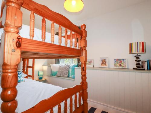 纽基Bro Tref Cottage的一间卧室配有木制双层床
