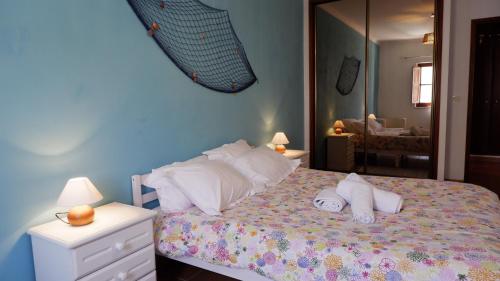 米尔芳提斯城Casa BARCA DO SOL的一间卧室配有带枕头和镜子的床