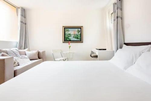 圣多明各Rincón Caribeño Habitación Privada的白色卧室设有一张大床和一张沙发