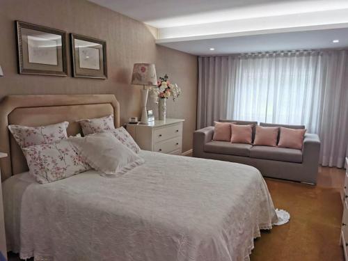 吉马良斯Casa das Camélias的一间卧室配有一张大床和一张沙发