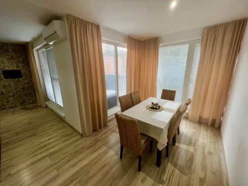 波切尼斯Apartman De lux 85m2的一间带桌椅和窗户的用餐室