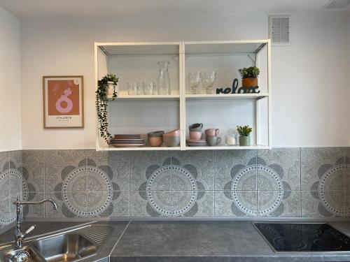 克罗斯诺Apartamenty Cud Miód的厨房设有水槽和餐具架