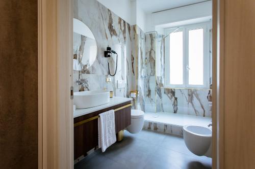 斯培西亚Elegant Apartments 5 terre la spezia的浴室配有2个盥洗盆、卫生间和浴缸。