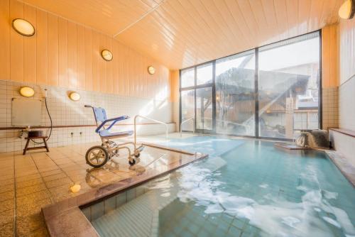 米泽市Tofuya Ryokan, Onogawa Onsen, Sauna, Barrier-free的室内大型游泳池,室内配有椅子