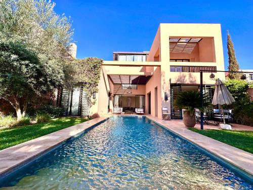 马拉喀什Al Maaden Ryad 69 a Marrakesh的房屋前有游泳池的房子
