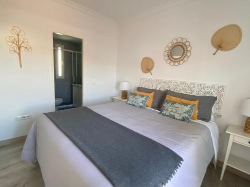 桑卢卡尔-德巴拉梅达Atico Infanta Eulalia的卧室配有带橙色枕头的大型白色床