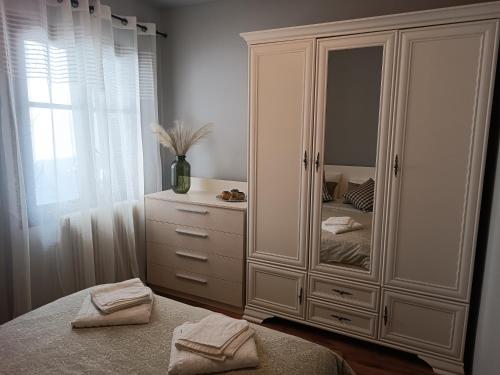 新安希亚洛斯Betty's Garden House的卧室配有带镜子的大型白色橱柜