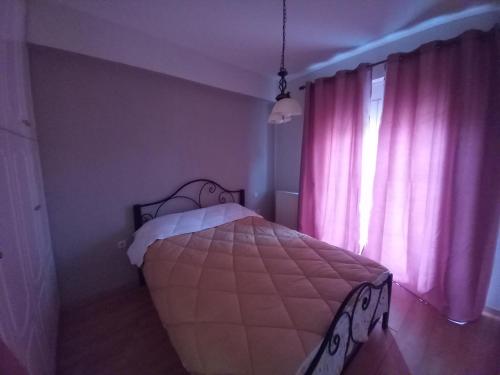 特里波利斯Tripoli Center的一间卧室配有床和一个带粉红色窗帘的窗户。