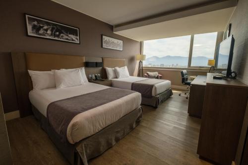 兰卡瓜Hotel Terrado Rancagua的酒店客房配有两张床和一张书桌