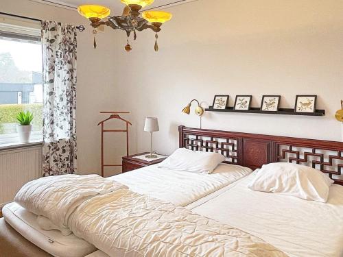 瑟尔沃斯堡Holiday home SÖLVESBORG XII的一间卧室设有两张床、一个窗户和一个吊灯。