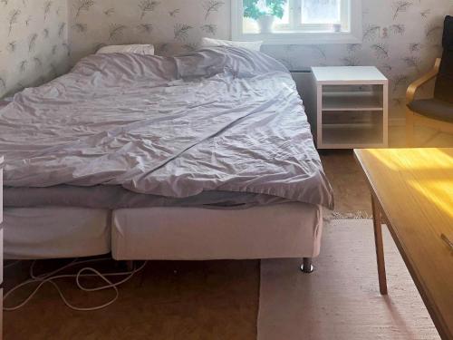 厄斯特松德Holiday home ÖSTERSUND的卧室内的一张未铺床,配有桌子