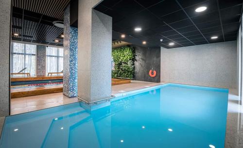 ĶesterciemsSeaside apartment Albatross, spa and pool的大楼内的一个蓝色海水游泳池