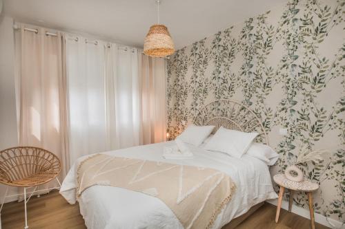 阿雷纳斯德圣佩德罗El Refugio de Sabina的卧室配有白色床和花卉壁纸