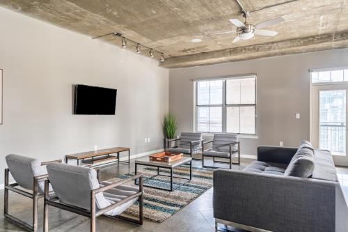 奥斯汀Kasa Downtown Austin的客厅配有沙发、椅子和电视