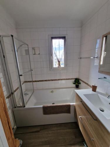 马赛appartement marseille velodrome的白色的浴室设有浴缸和水槽。