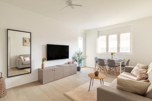 卢加诺Lugano Superior Suites - Free Parking的客厅配有电视和桌椅