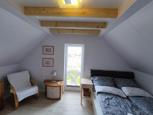 尼彻兹Baltic Rafa的卧室配有床、椅子和窗户。