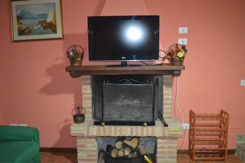 斯波莱托Casa Borgo Marco e Cristina的壁炉顶部的电视,顶部的电视