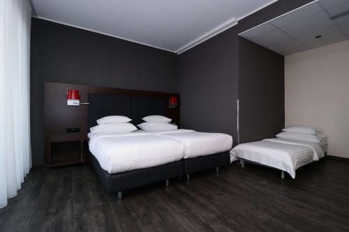 格拉茨Best Western Plus Plaza Hotel Graz的配有2张床的带白色床单和枕头的客房