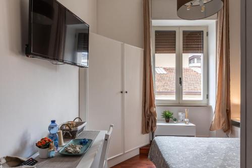 圣塞韦罗B&B della Stazione的小房间设有床、桌子和电视