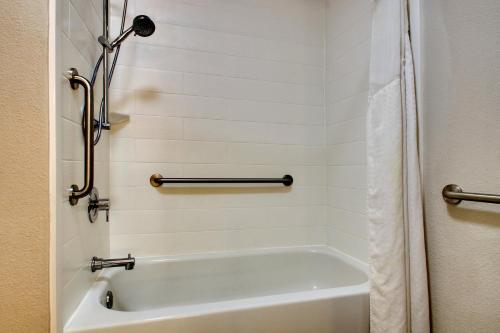 劳雷尔Holiday Inn Express & Suites Laurel, an IHG Hotel的带淋浴的浴室配有白色浴缸。