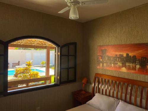 布希奥斯Casa Três Amores的一间卧室设有一张床和一个美景窗户。