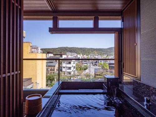 京都Sora Niwa Terrace Kyoto Bettei的一间带浴缸的浴室,享有城市美景