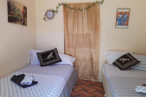 斯卡伯勒Cocoa Cabana的一间卧室设有两张床和一个带窗帘的窗户。