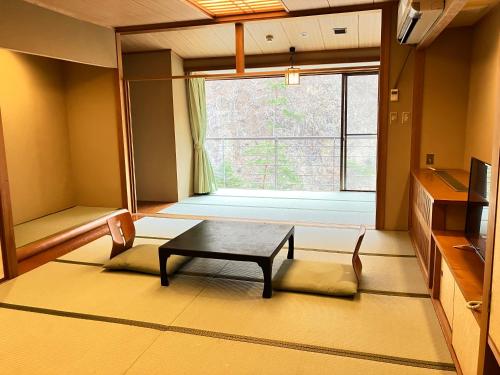 日光汤西川日式旅馆的客厅配有桌子和窗户