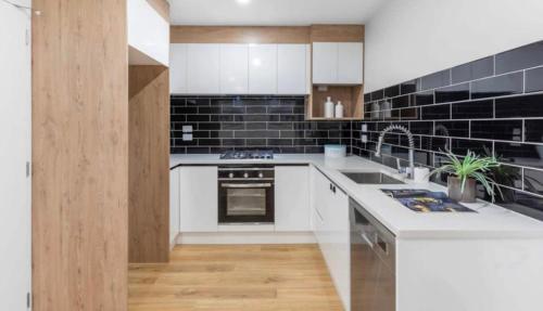 奥克兰Private room near Auckland Airport的厨房配有白色的柜台和黑色的瓷砖