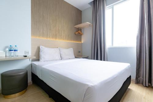 棉兰Swasana Hotel near Plaza Medan Fair Mitra RedDoorz的酒店客房设有白色的床和窗户。