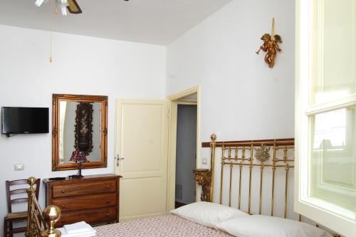 利多迪卡马约雷Old Time Lido的卧室配有一张床,墙上设有镜子