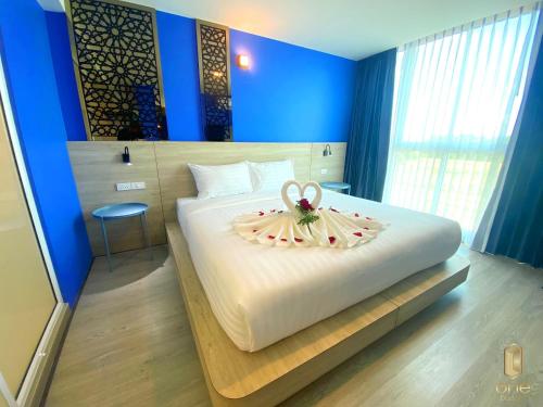 清莱วัน บัดเจท เชียงราย สนามกีฬา One Budget Hotel Chiangrai Stadium的一间卧室配有一张白色大床,床上有鲜花
