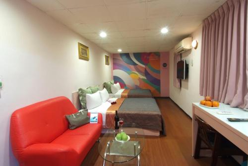新竹東賓快捷旅店的一间医院房间,配有一张床和一张红色的沙发