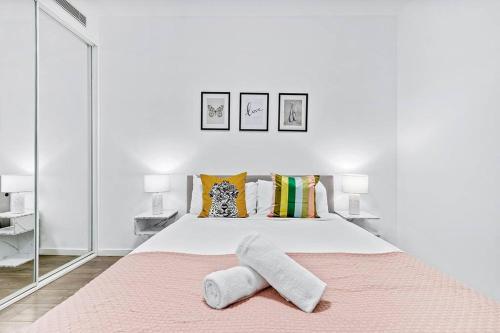 悉尼Centre of Newtown 2 Bed Apartment的白色卧室配有一张大床和两条毛巾