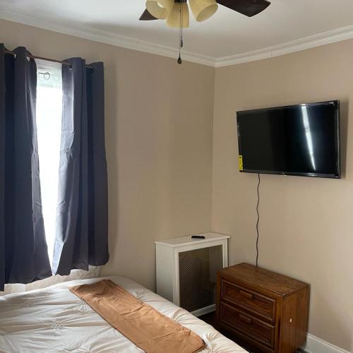 Saint AlbansDon cozy的卧室配有一张床和壁挂式平面电视。