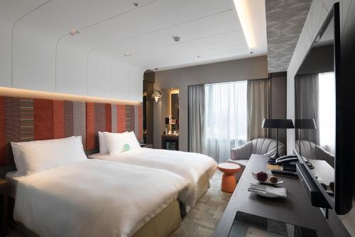 台北台北亚都丽致大饭店的酒店客房设有两张床和电视。