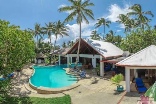 TanganggeThe Jewel of The Coral Coast的一个带游泳池和棕榈树的度假村